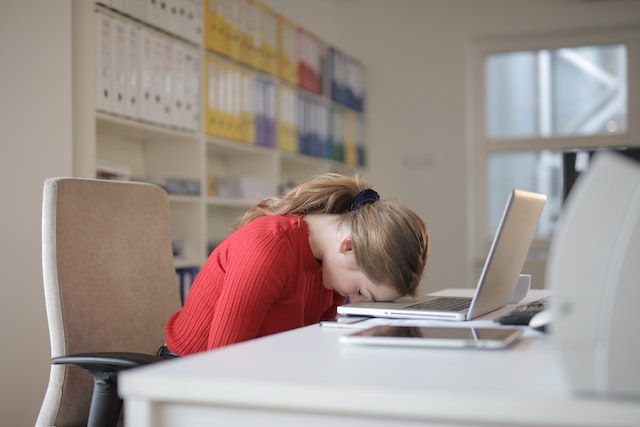 Image of a female asleep at a laptop